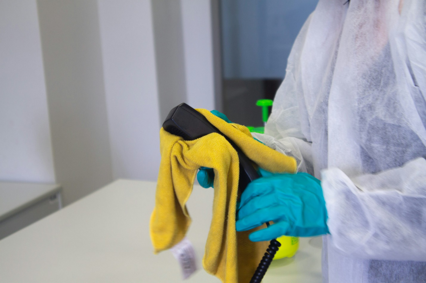 gloved hands holding a yellow cloth